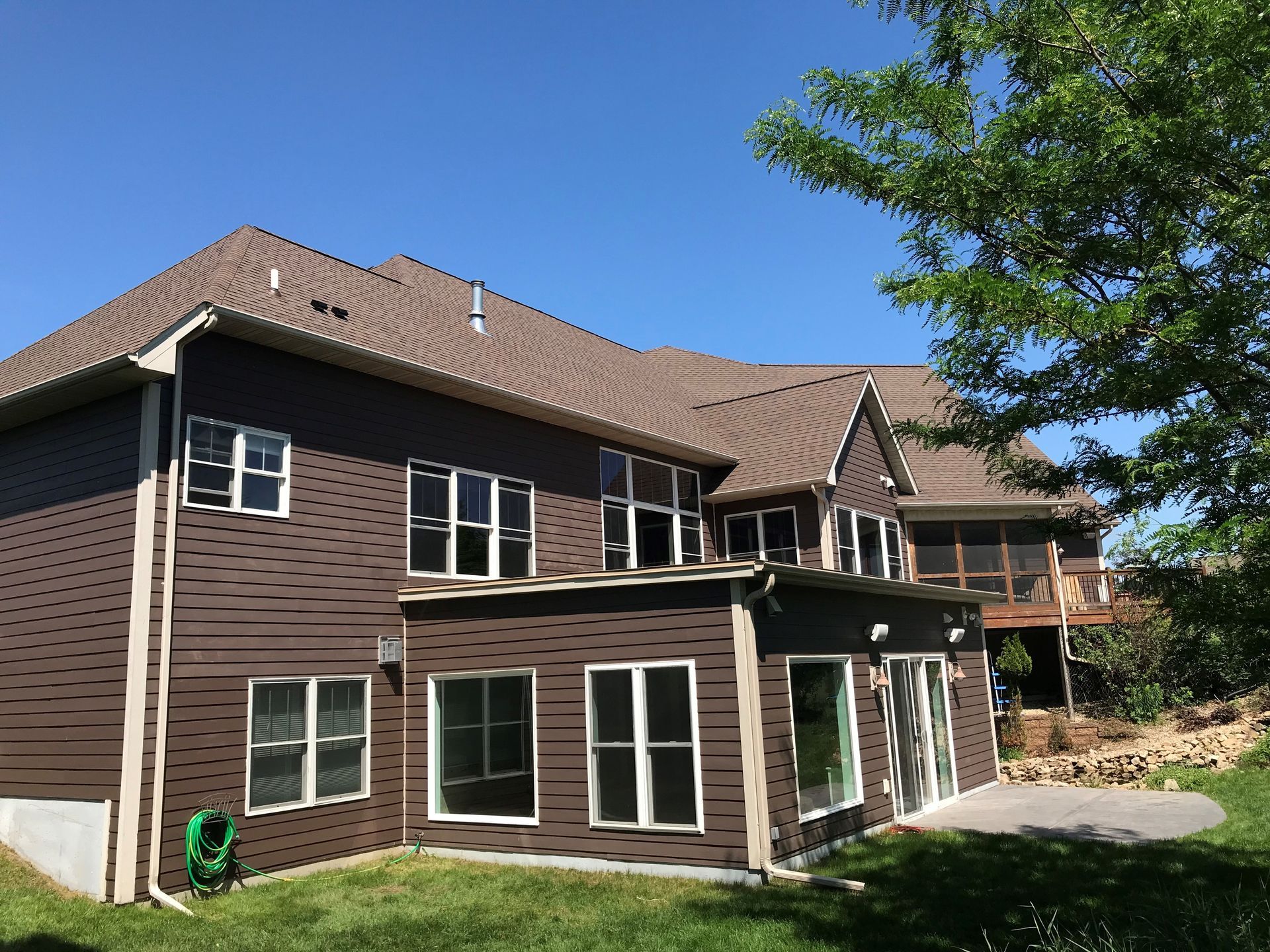 A large brown house with a lot of windows and a roof