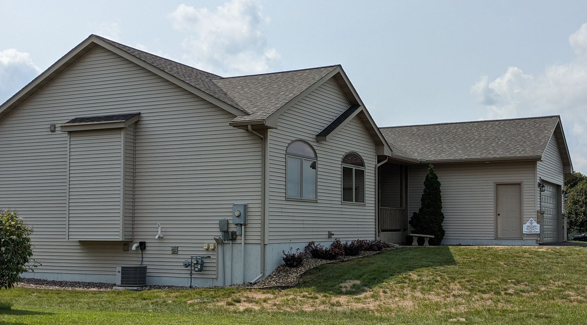 The back of a house with a sign that says 