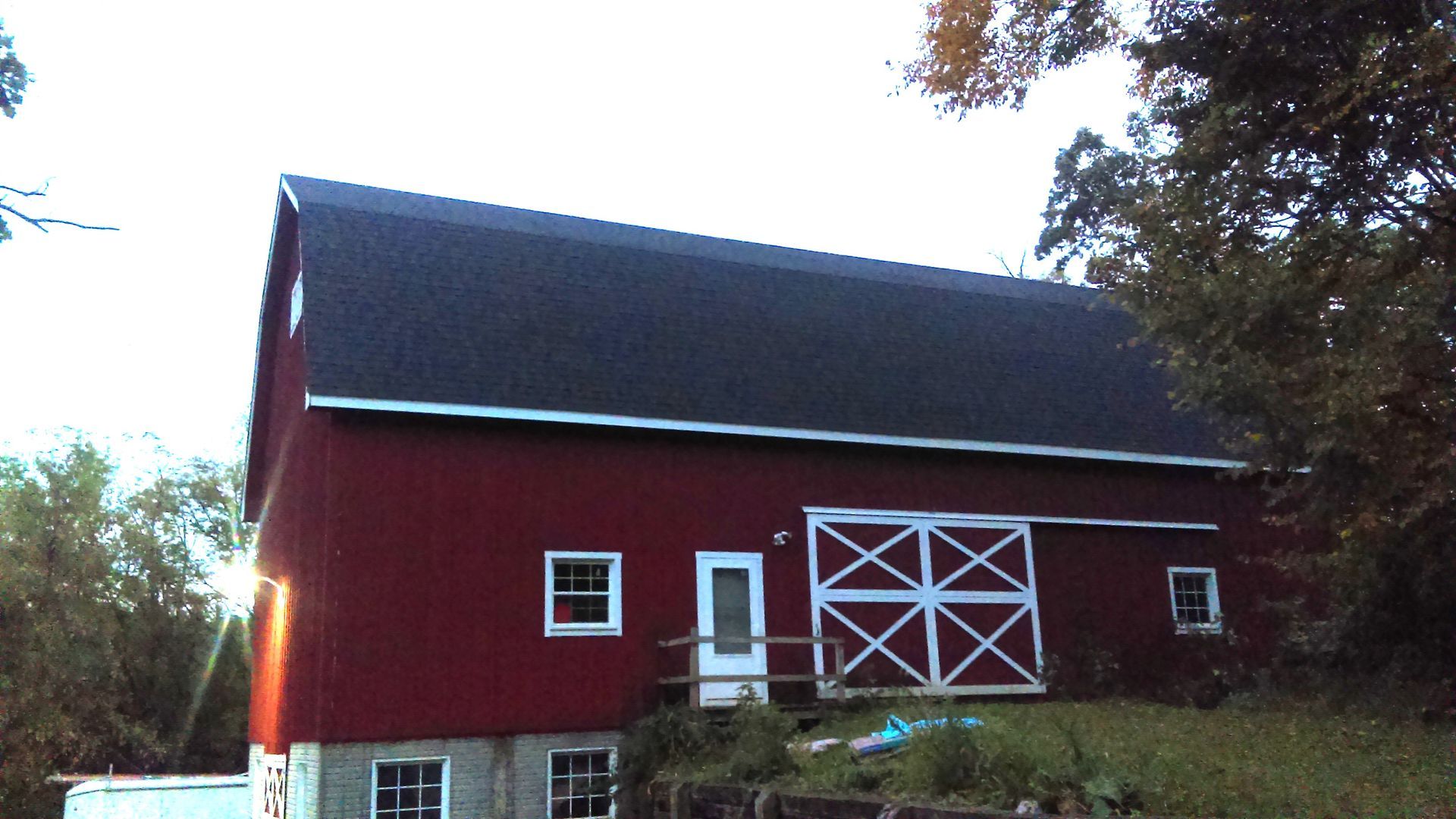 A red barn with a black roof and white doors