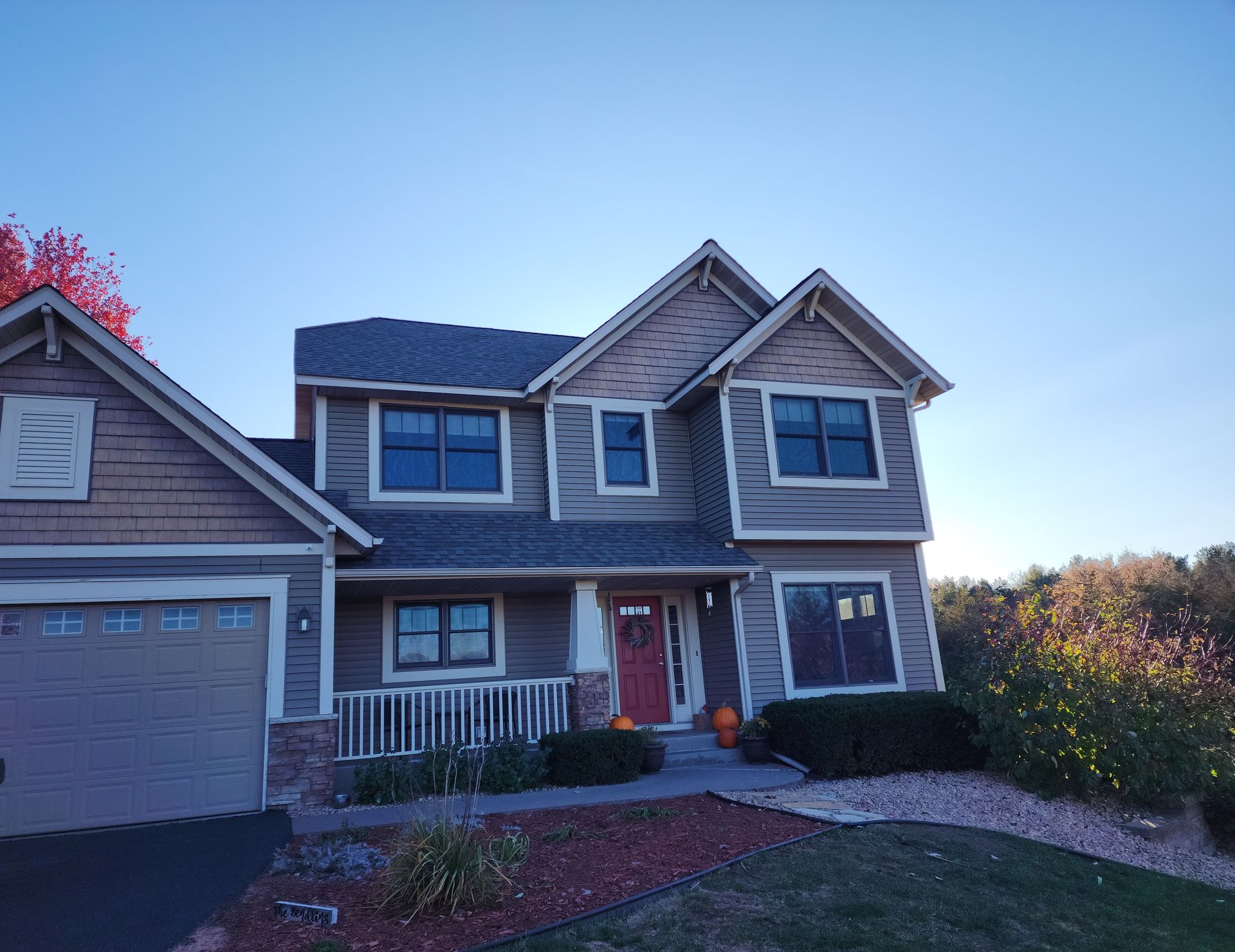 A large house with a red door and a garage