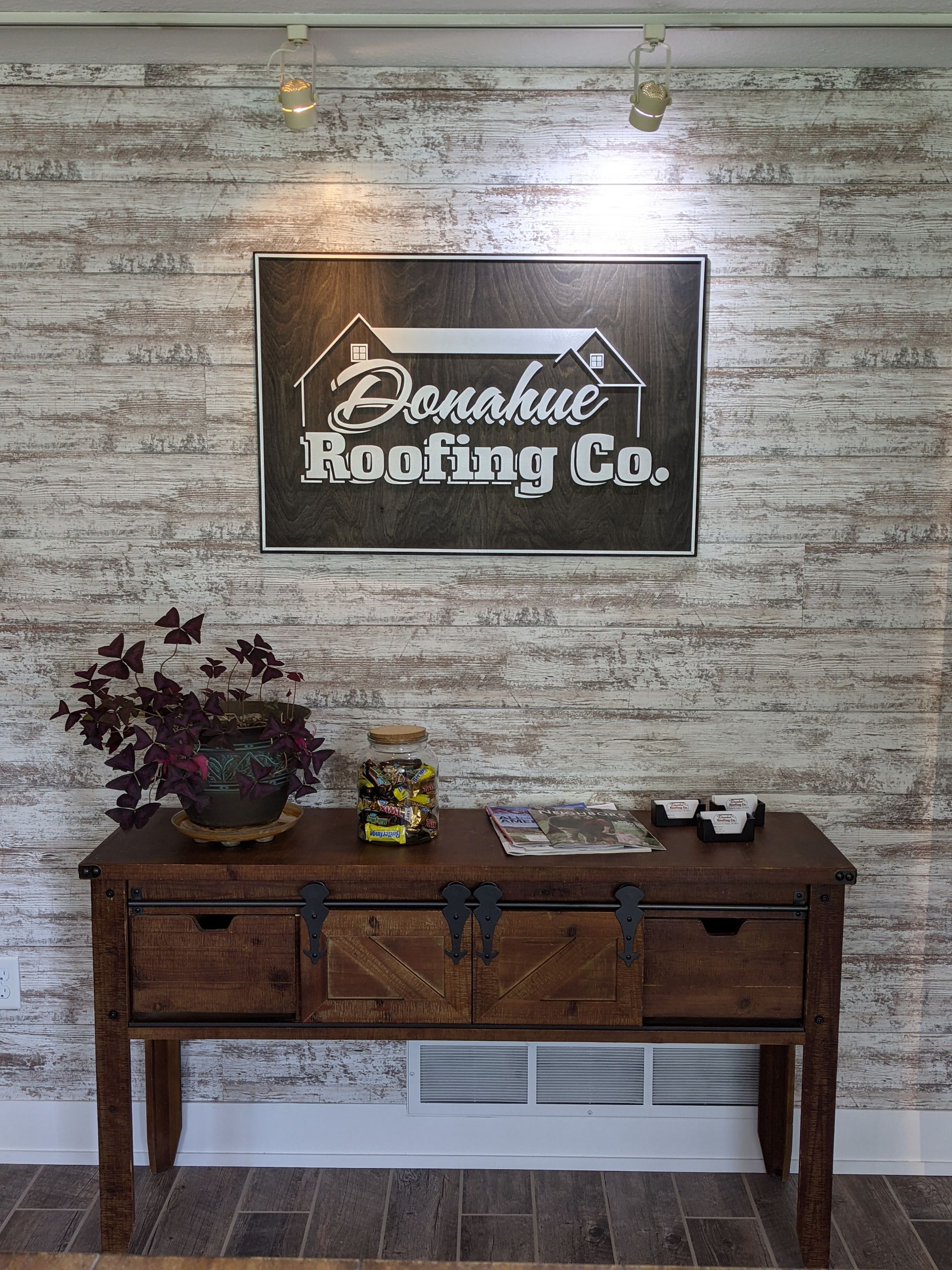 A wooden table with a sign on the wall above it.