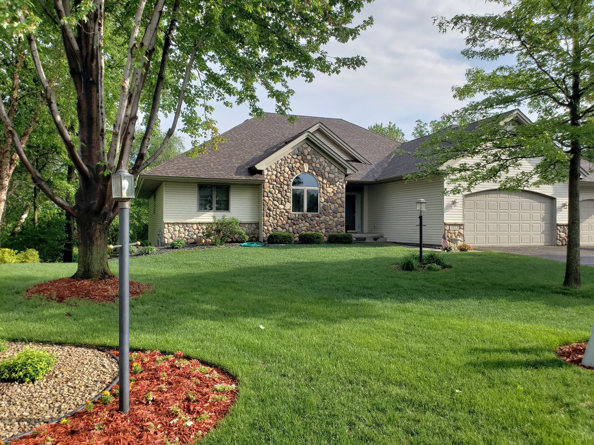A house with a lot of grass and trees in front of it