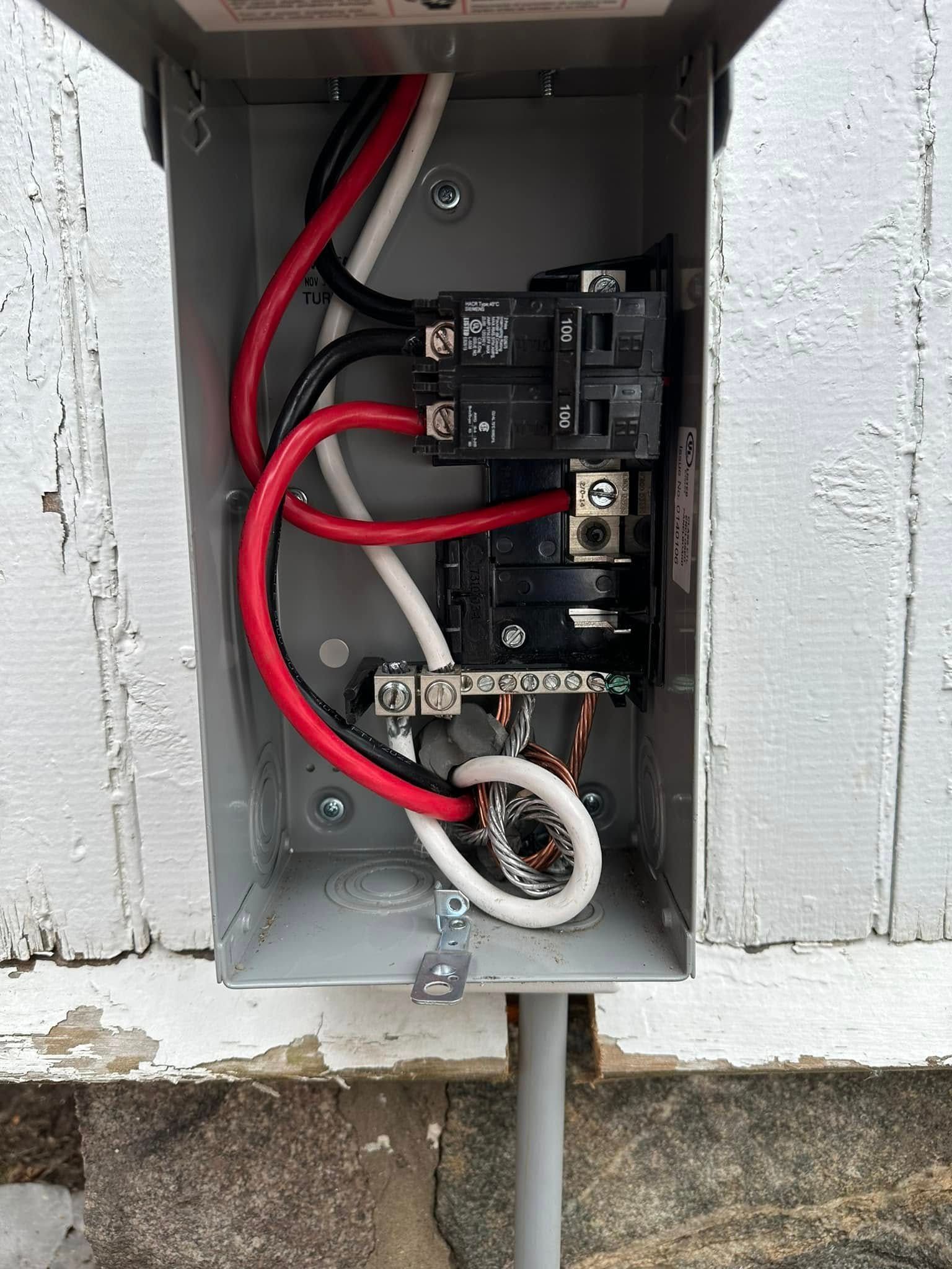 A close up of an electrical box with wires coming out of it.