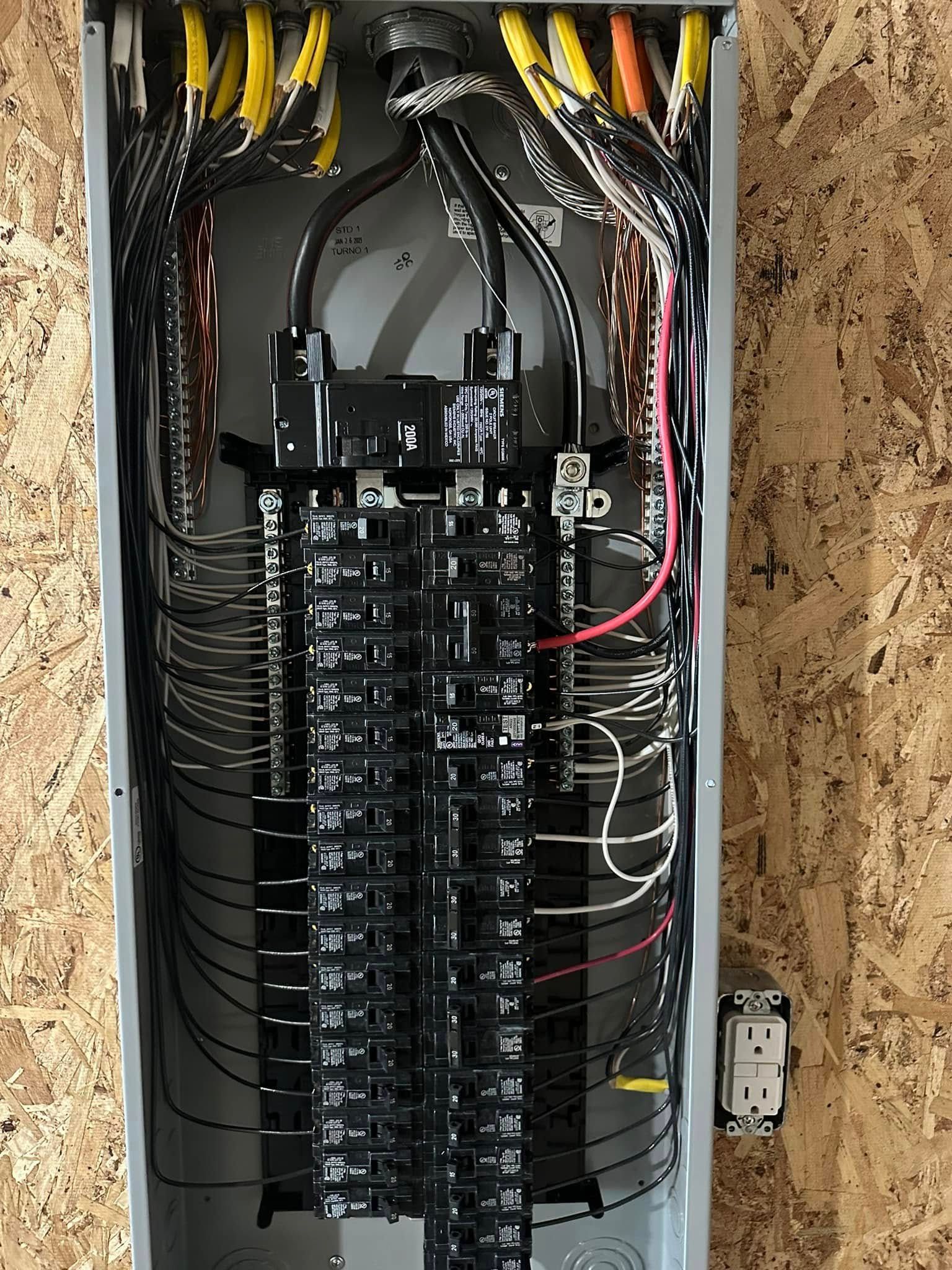 A close up of a electrical panel with a lot of wires coming out of it.