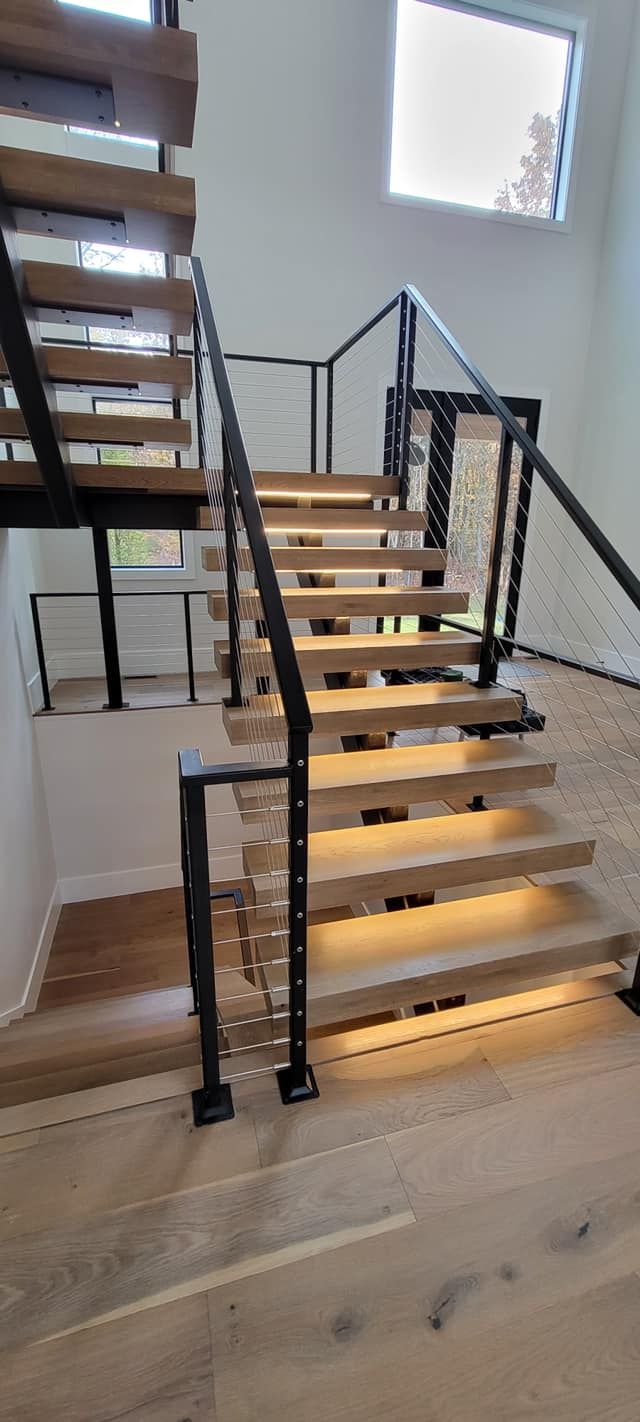 A wooden staircase with lights on the steps in a house.