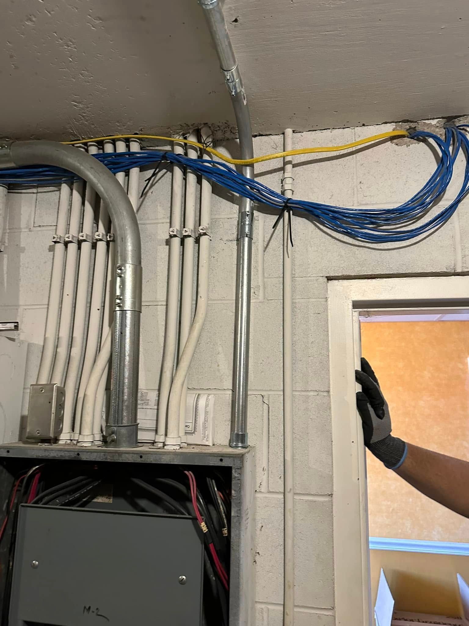 A person is standing in a room with a bunch of wires hanging from the ceiling.