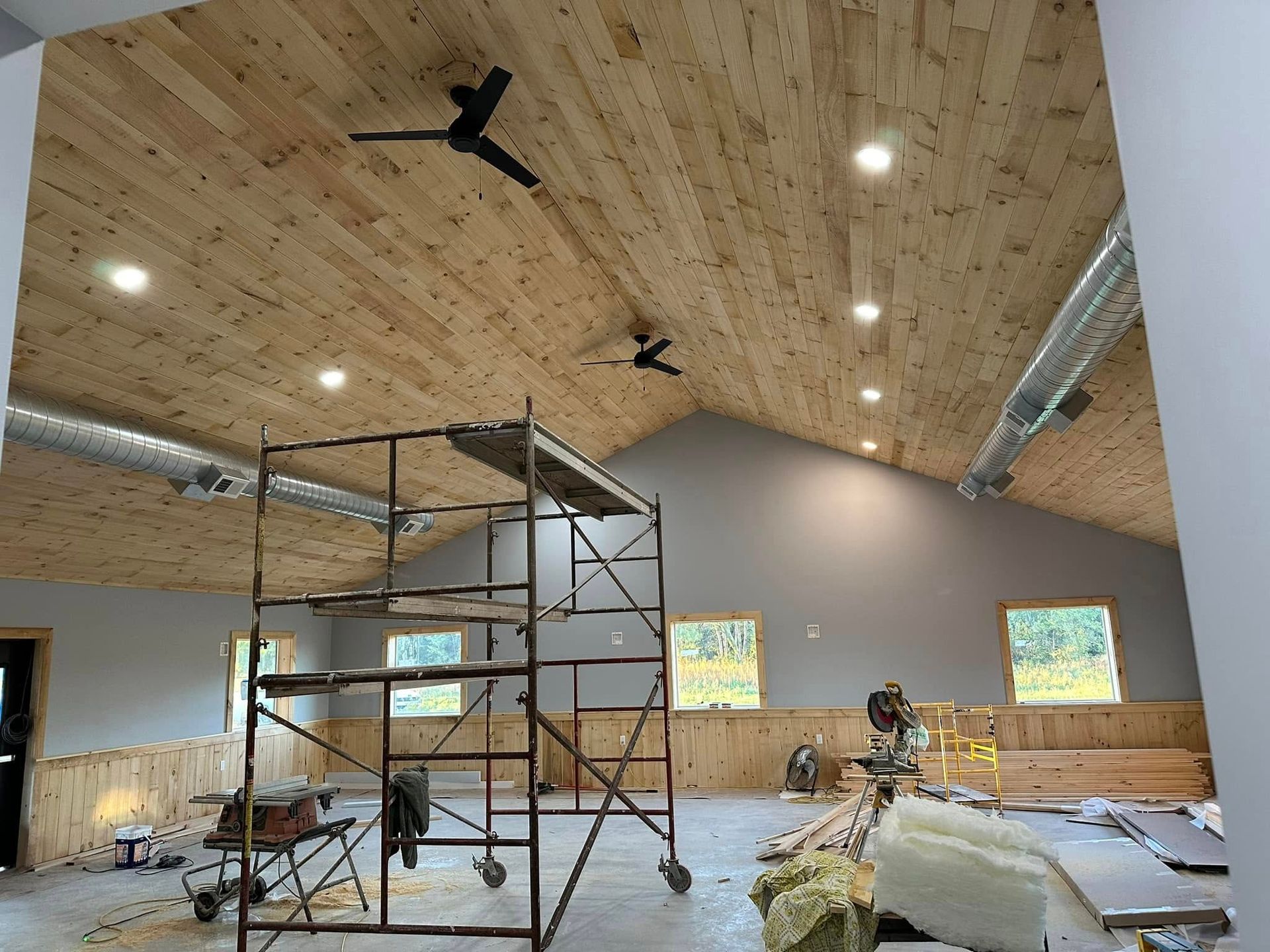 A large room with a wooden ceiling and a ceiling fan.