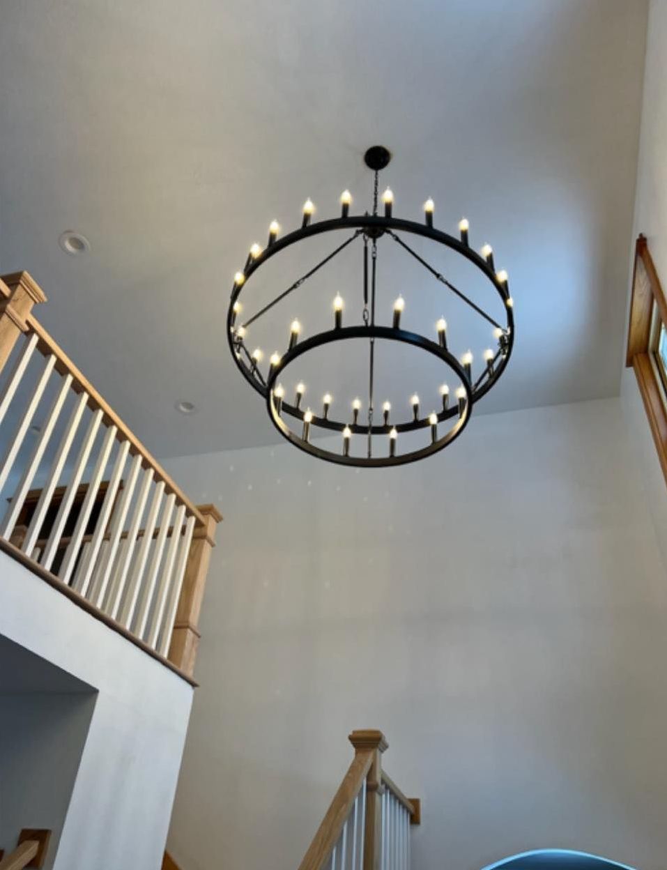 A large chandelier is hanging from the ceiling above a staircase