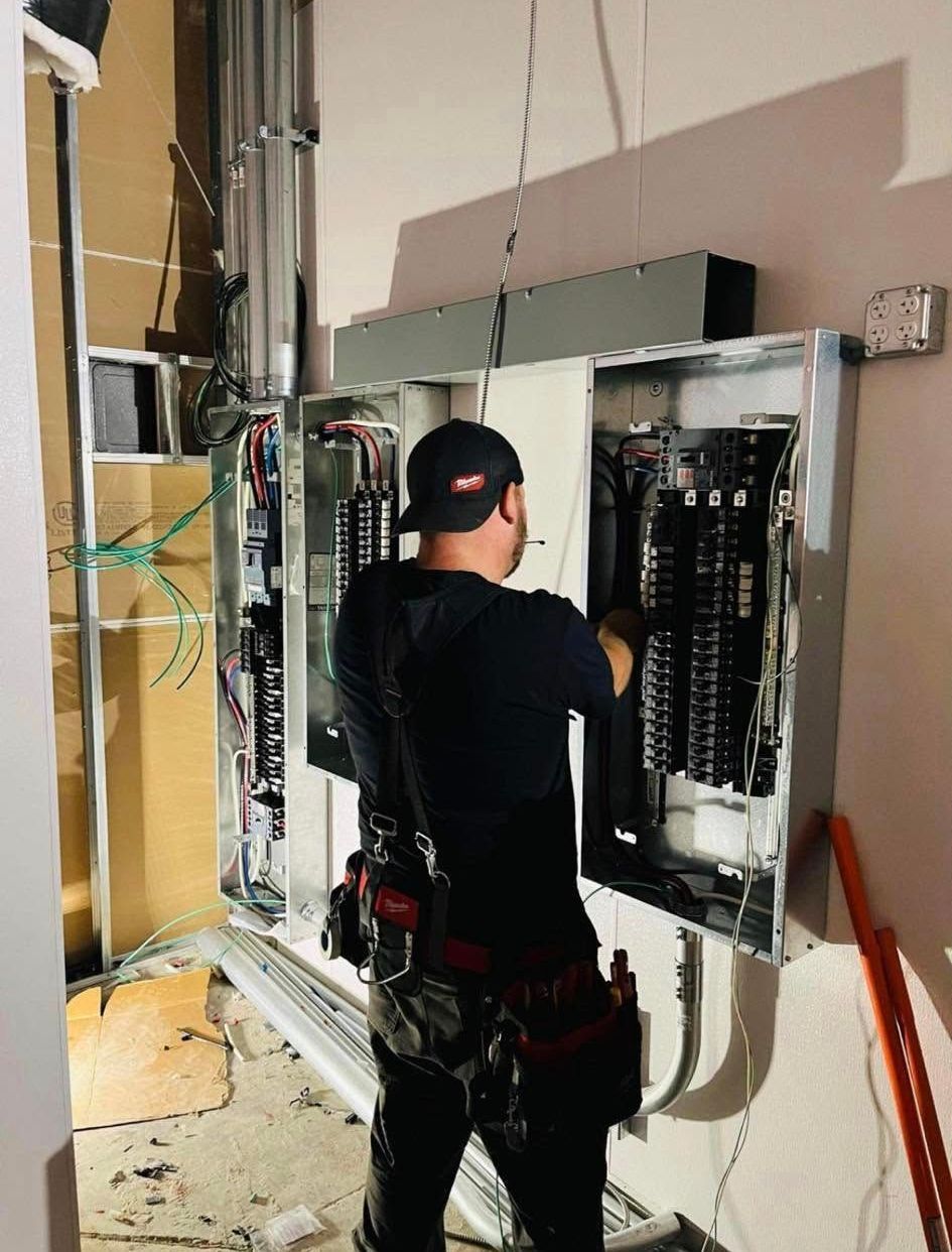 A man is working on an electrical box in a room.
