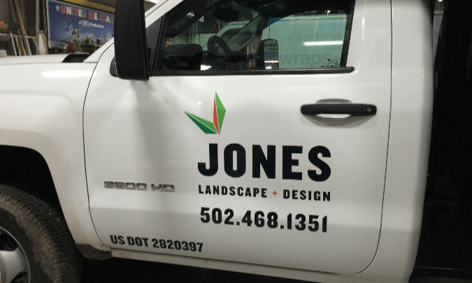 White Jones Landscape + Design truck door with company logo and phone number