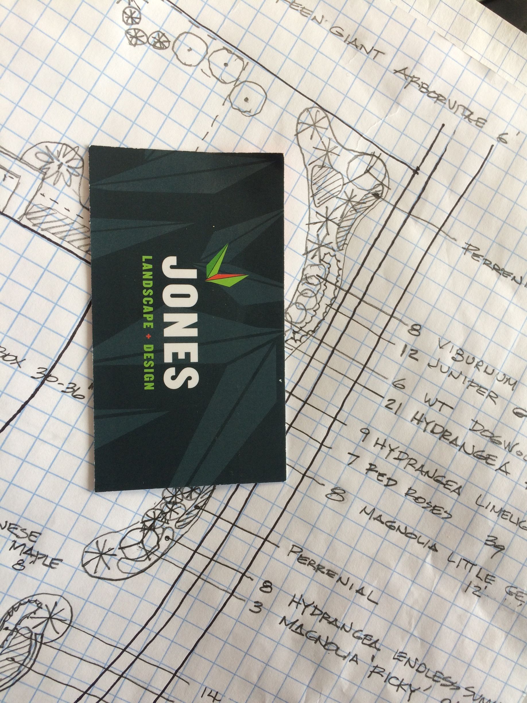 Jones business card on a blueprint-style background, black card with green and white text.