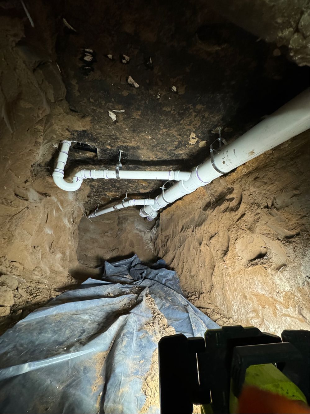 A drain pipe is being installed in a hole in the ground.