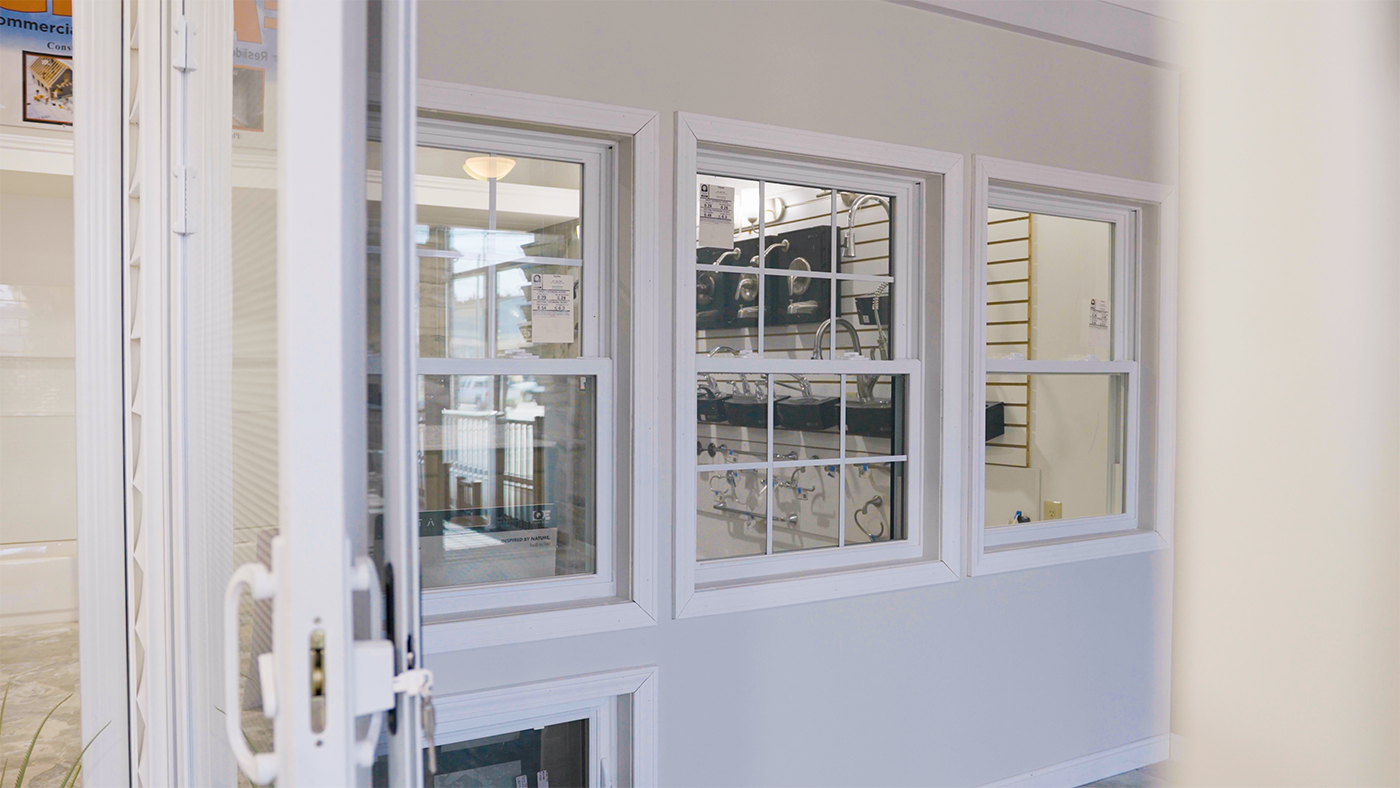 A white door is open to a room with a lot of windows.