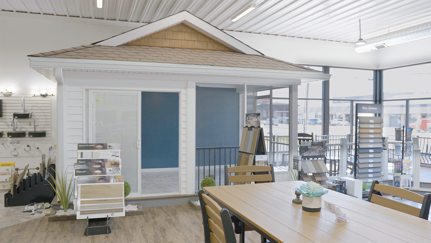 A room with a table and chairs in front of a small house.