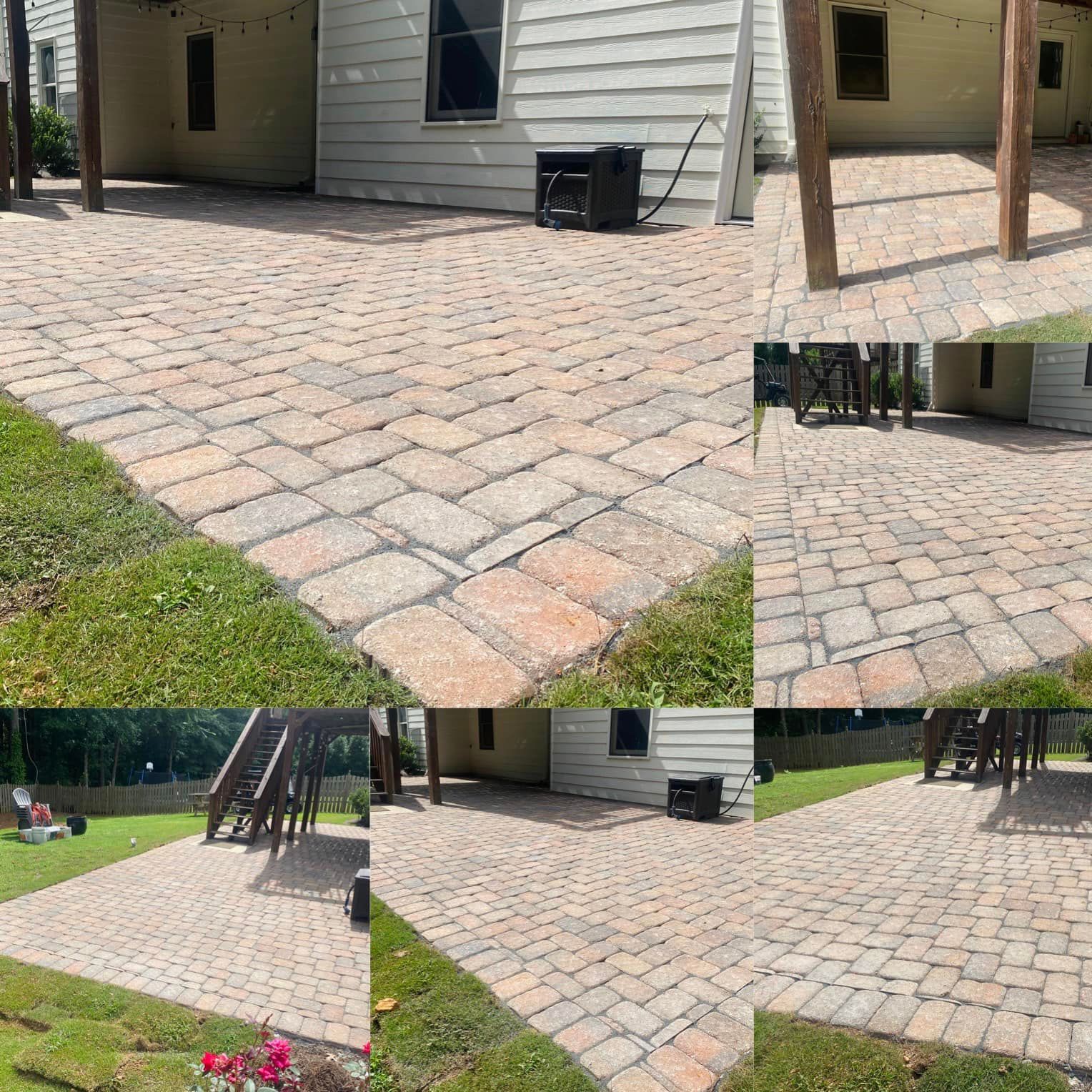 Patio paved with interlocking bricks, next to a house with a small grassy area.