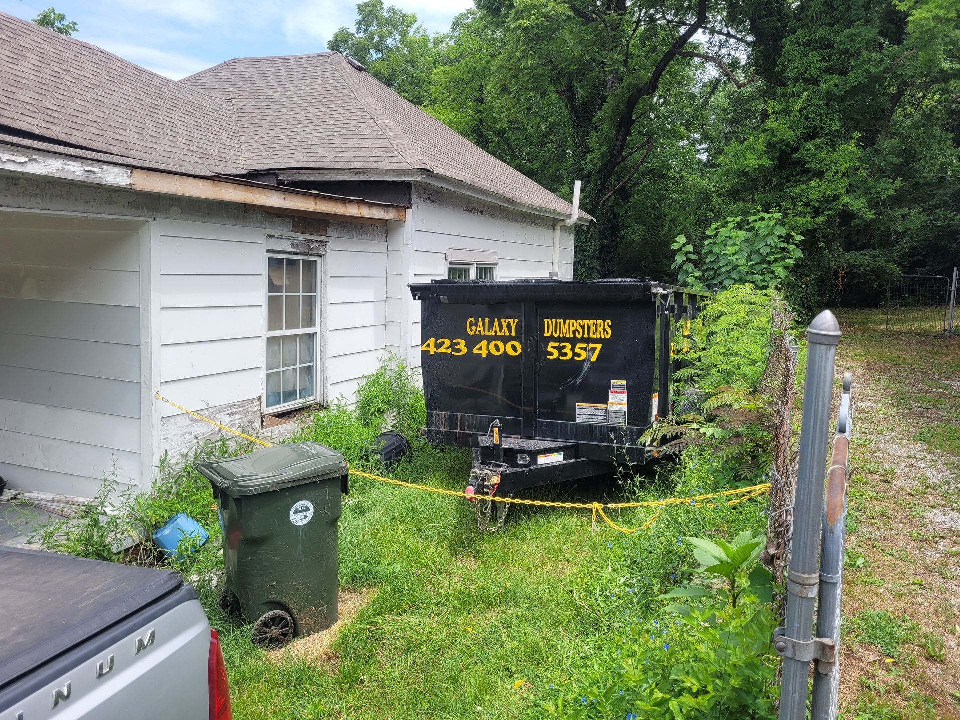 A dumpster is parked in front of a house.