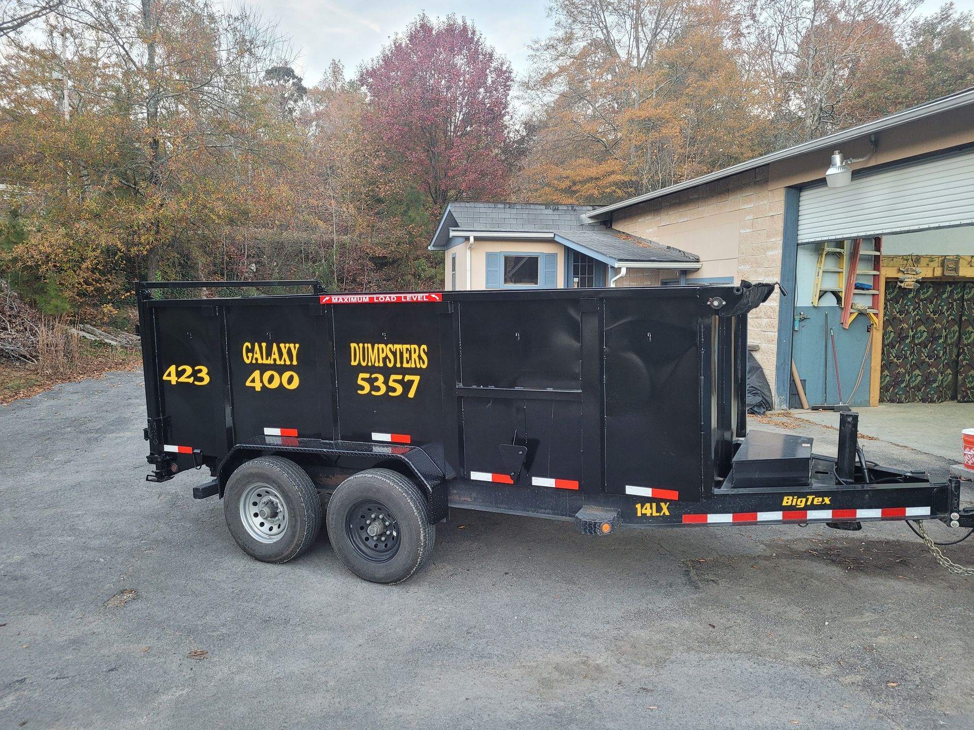 A dumpster trailer is parked in front of a building.