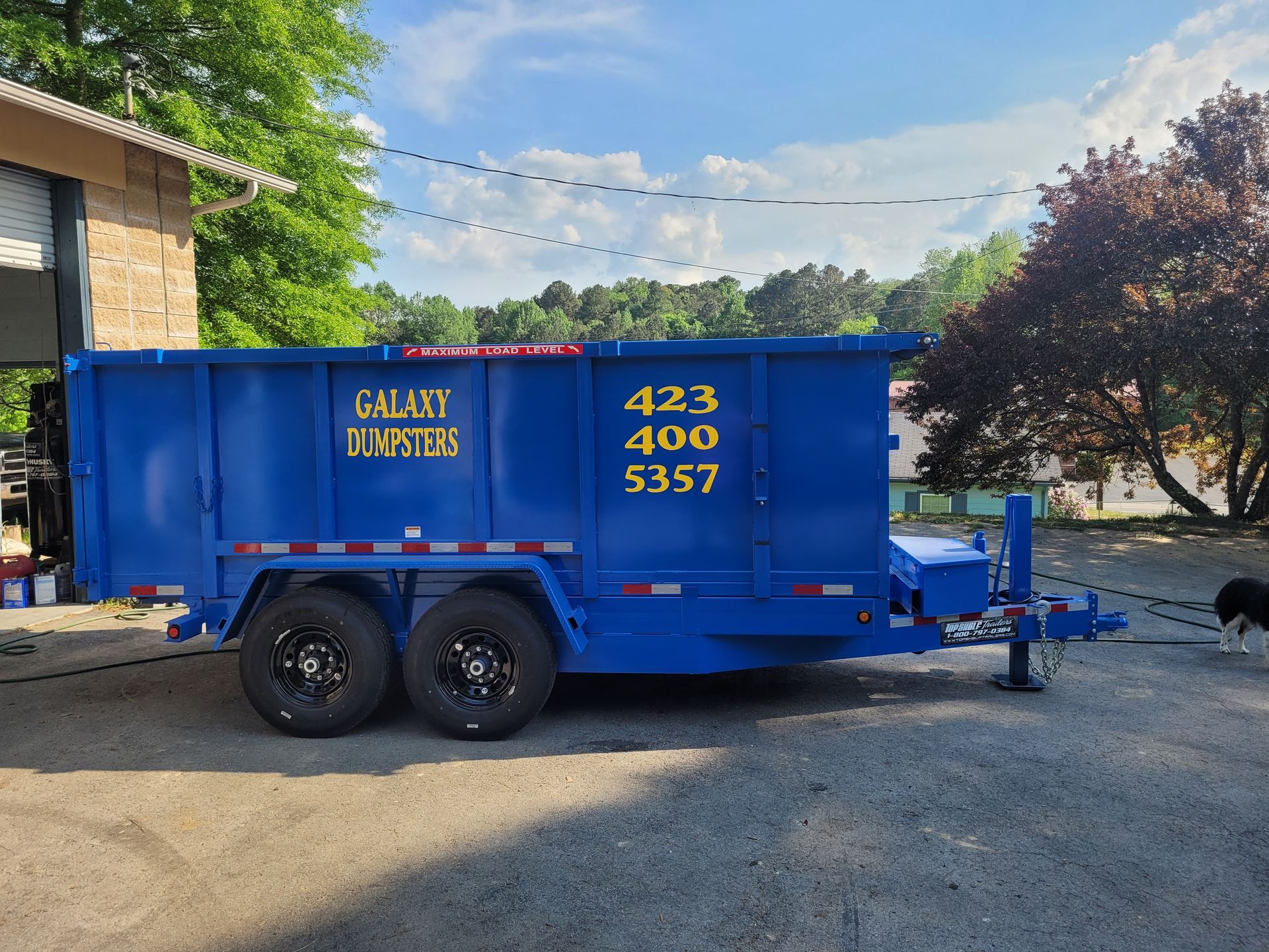 A blue dumpster with galaxy dumpster written on it