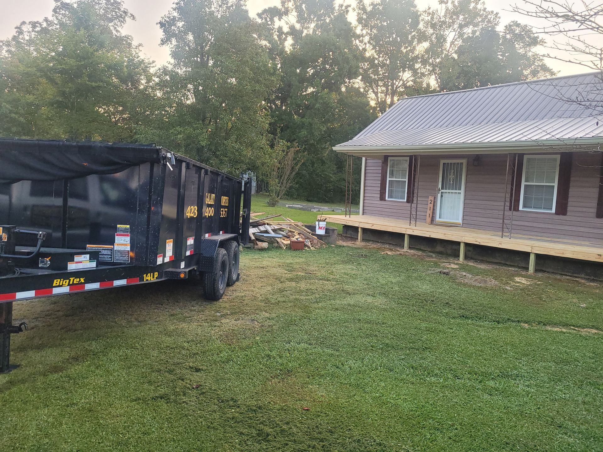 A dumpster is parked in front of a house.