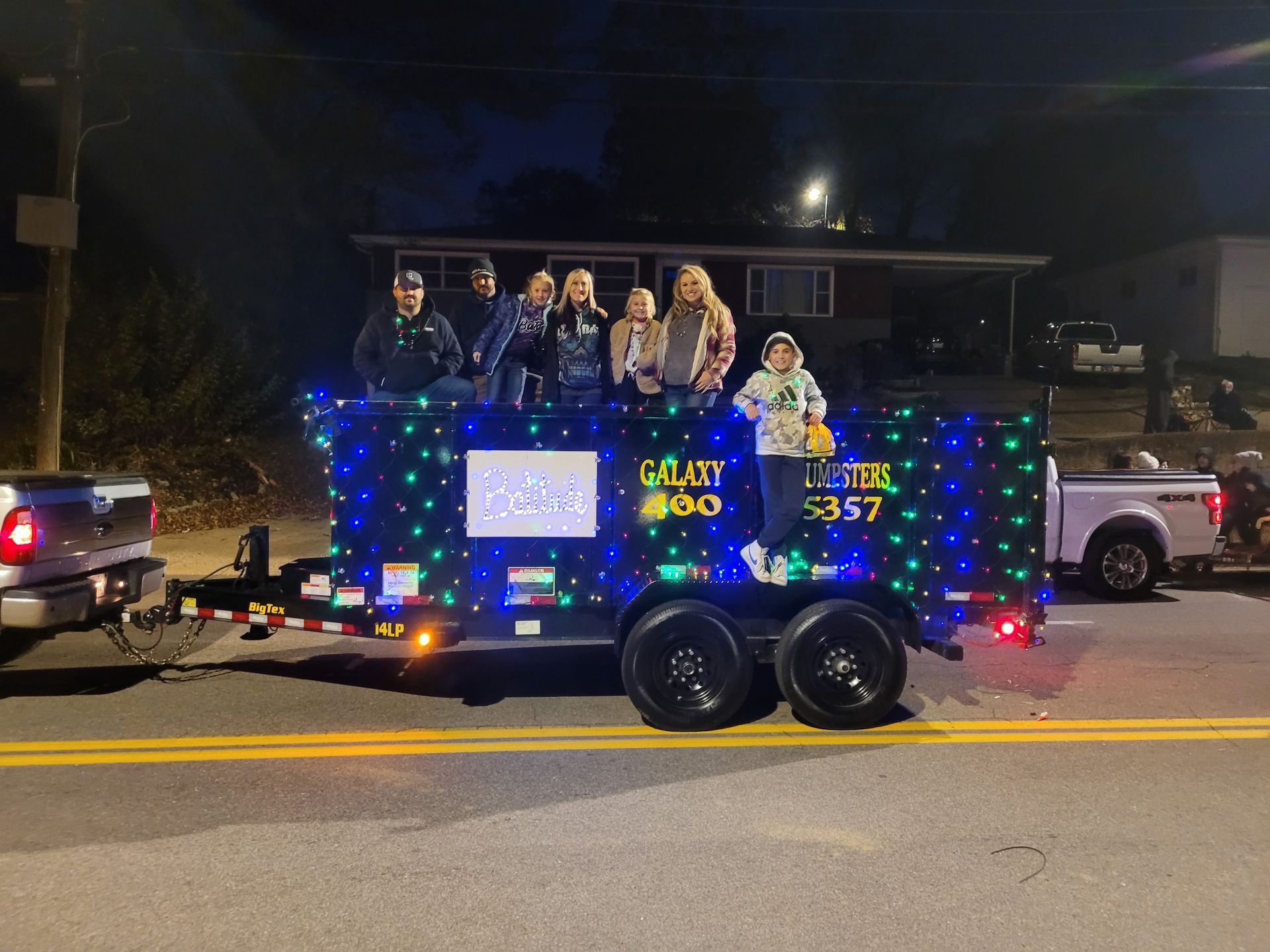 A group of people standing on top of a trailer that says goat