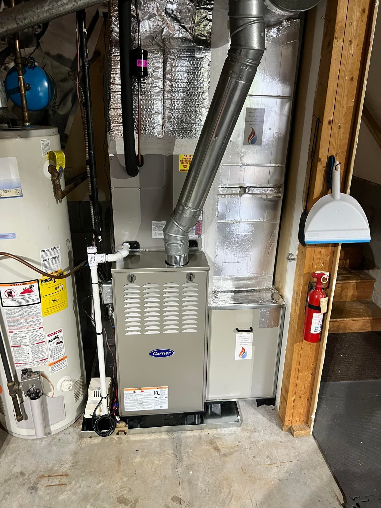 A furnace and a hot water heater in a basement with a metal flue, ductwork, and a dustpan hanging on a wooden post.