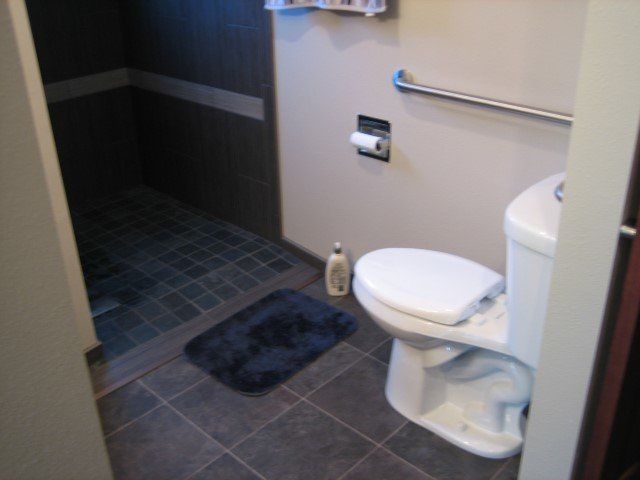 A toilet in a bathroom next to a shower