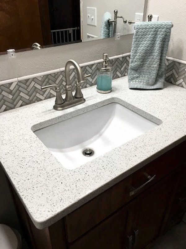 A bathroom sink with a soap dispenser and a towel on it.
