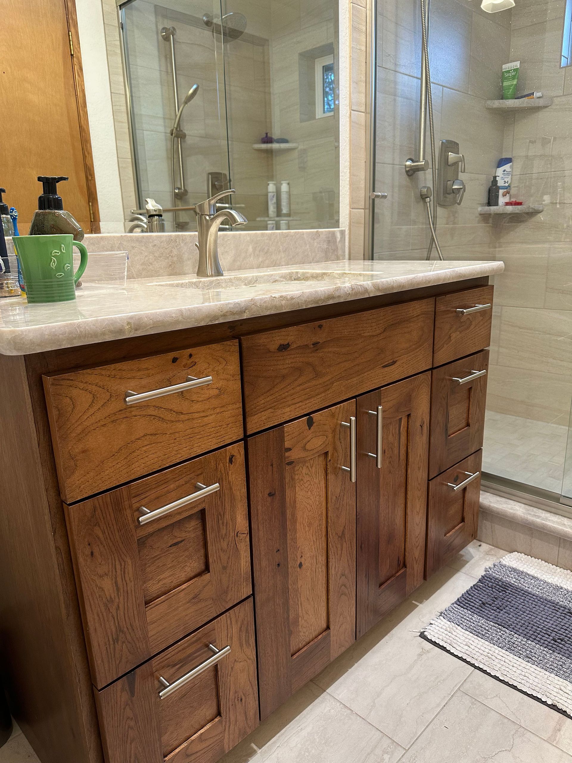 A bathroom with a sink , mirror , and drawers.