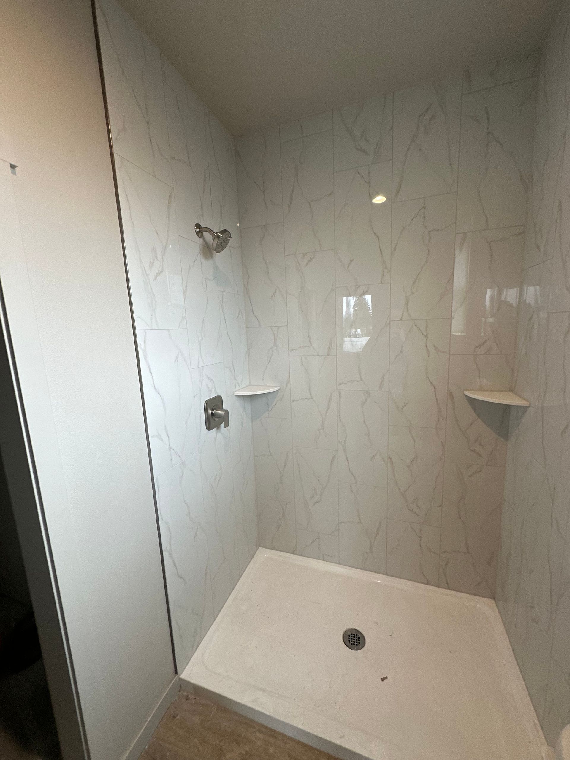 A bathroom with a walk in shower and a shower head.