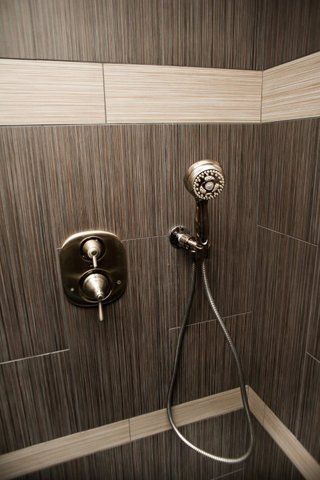 A close up of a shower head in a bathroom.