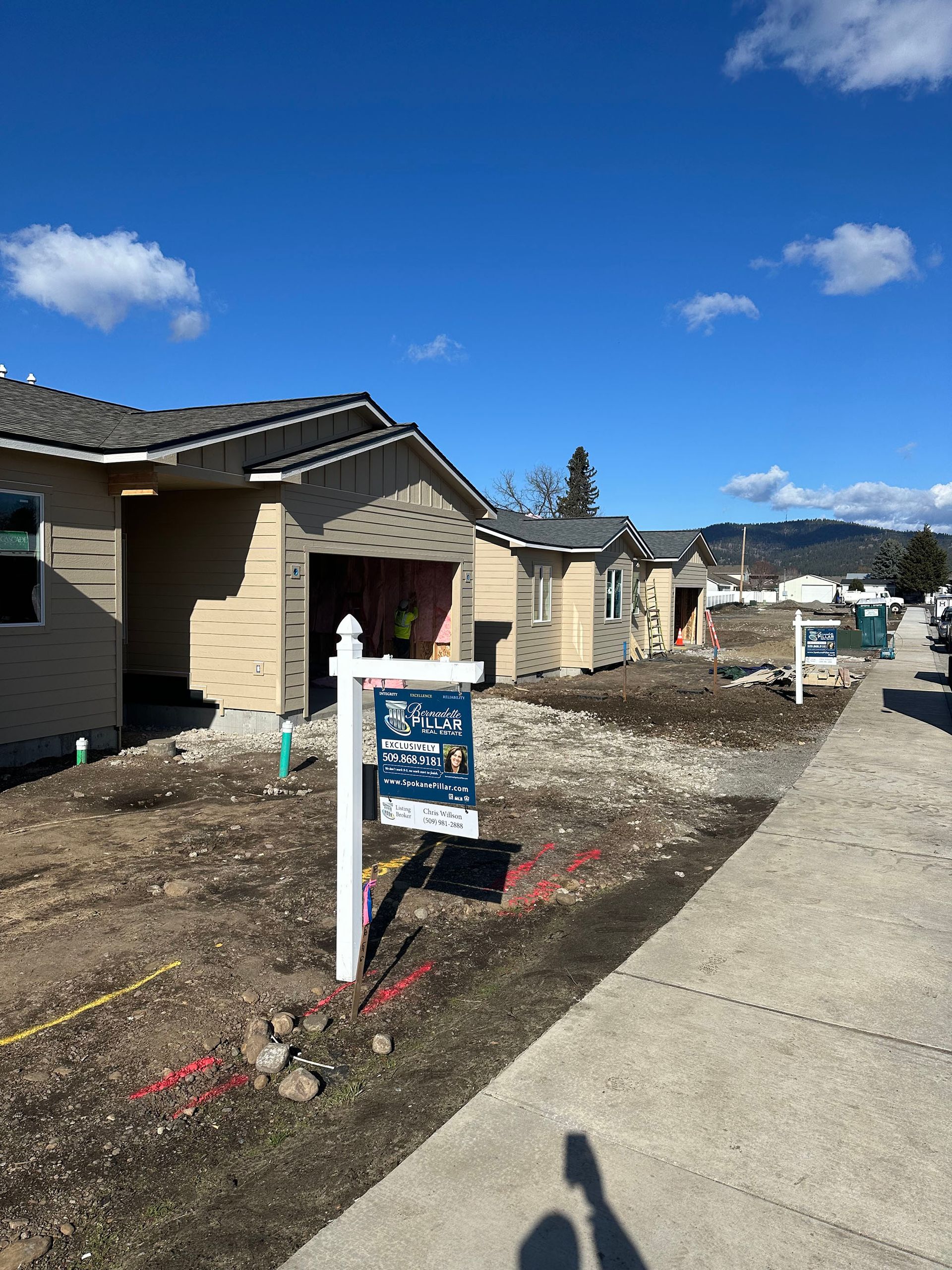 A house under construction with a for sale sign in front of it