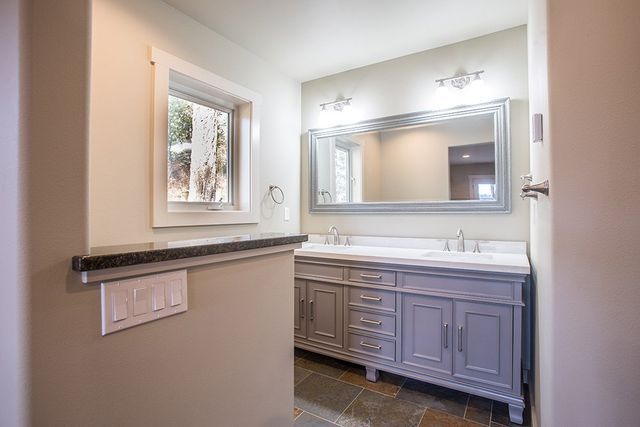 A bathroom with two sinks and a large mirror.
