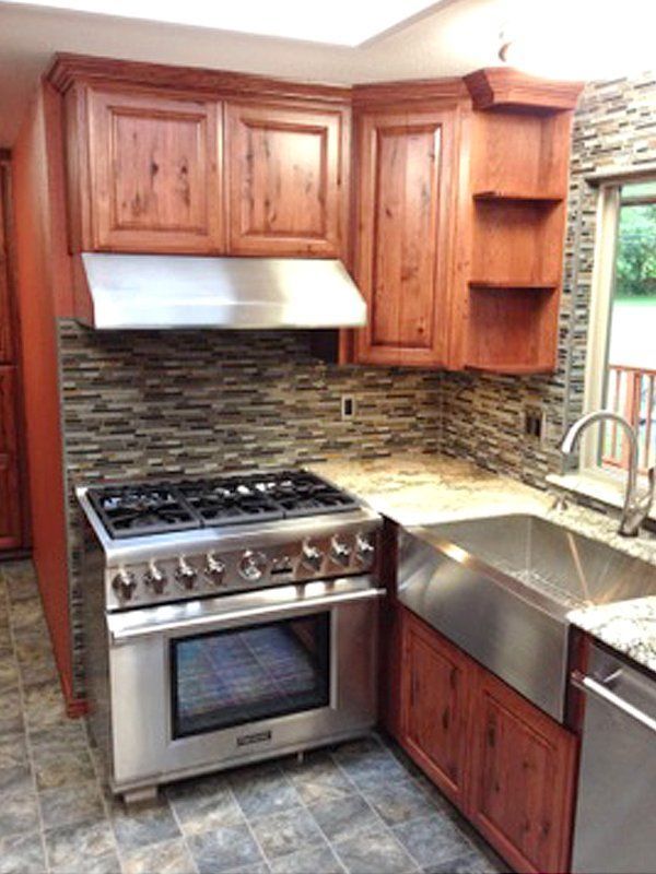 A kitchen with stainless steel appliances and wooden cabinets