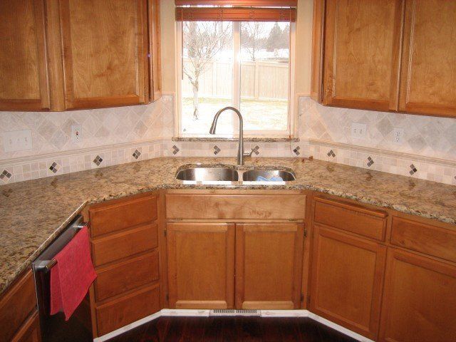 A kitchen with two sinks and wooden cabinets