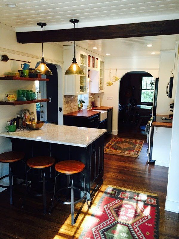 A kitchen with stools and a rug on the floor