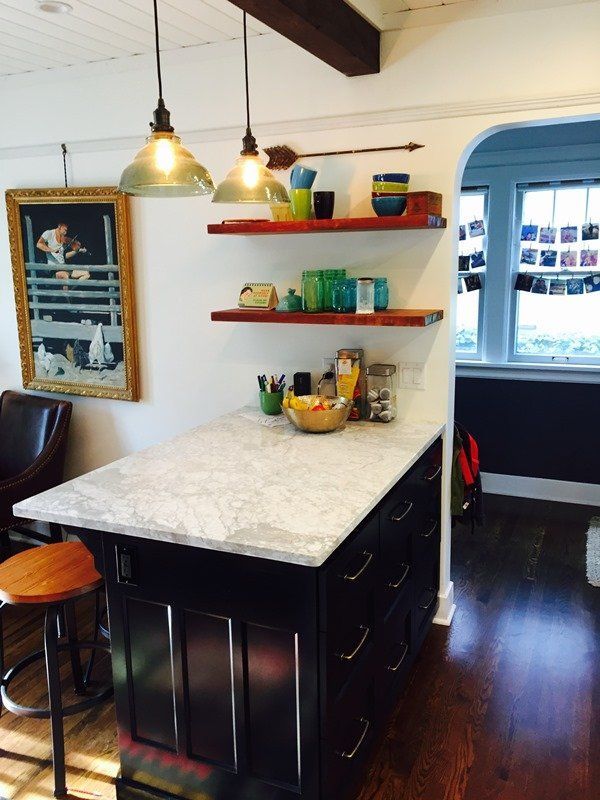 A kitchen with a large island with a marble counter top