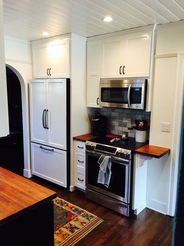A kitchen with stainless steel appliances and white cabinets