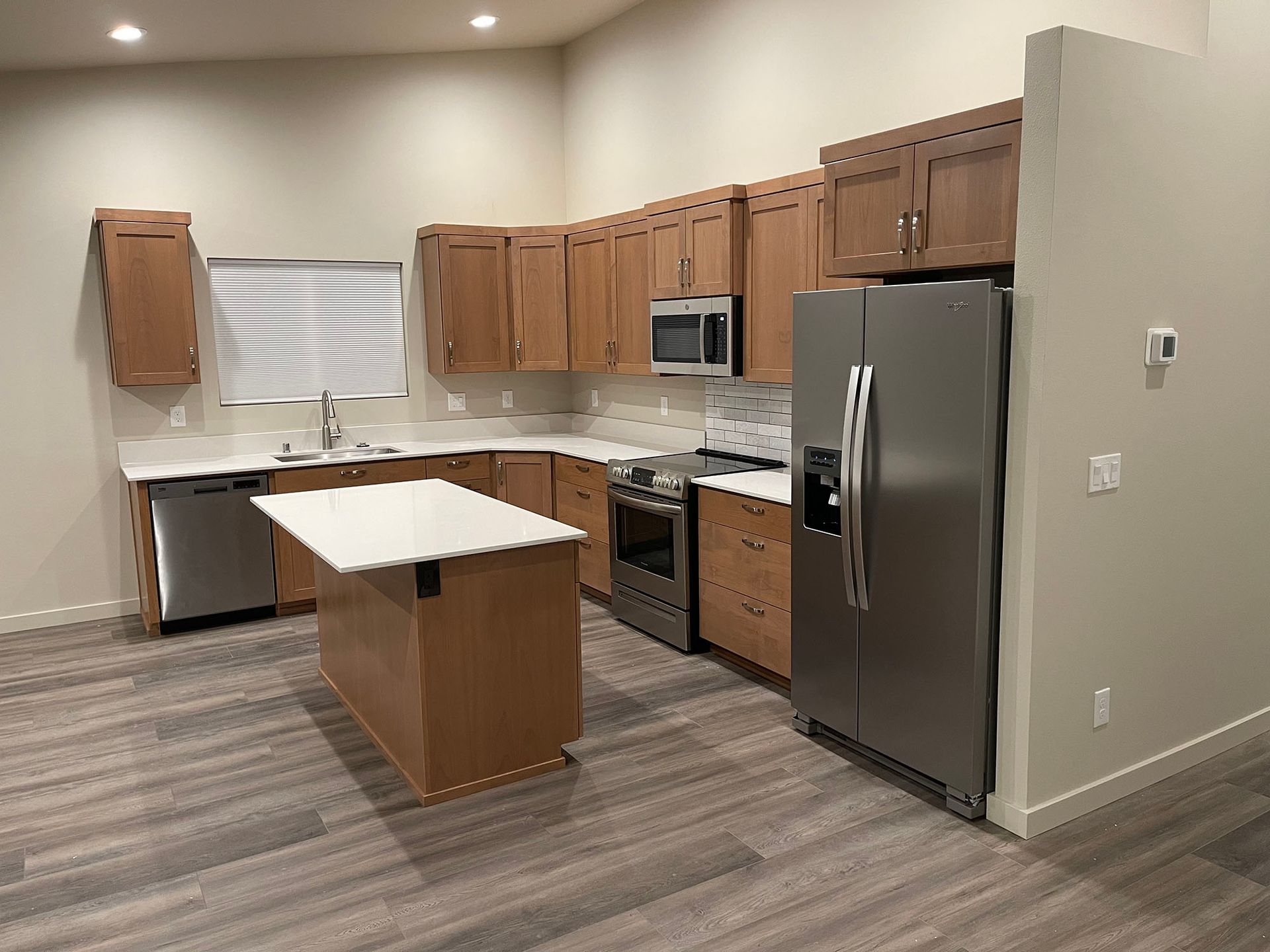 A kitchen with stainless steel appliances and wooden cabinets.