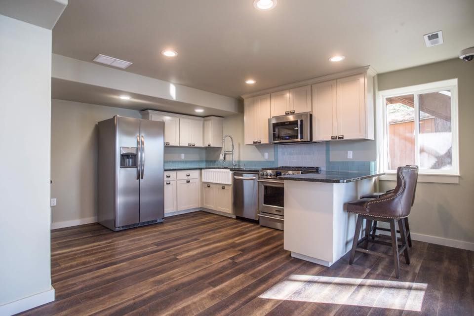 A kitchen with stainless steel appliances and hardwood floors.