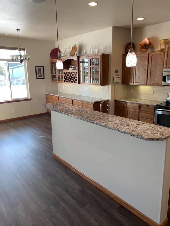 A kitchen with granite counter tops and wooden cabinets