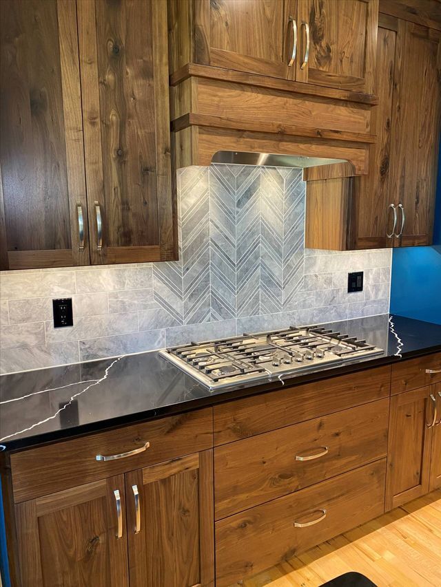 A kitchen with wooden cabinets and a stove top oven.