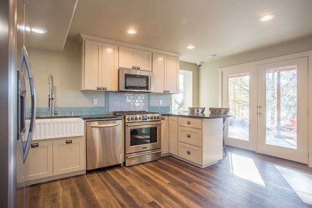 A kitchen with stainless steel appliances and white cabinets.