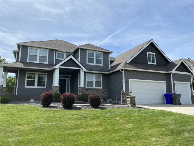 A large gray house with a white garage door