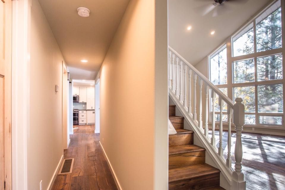A hallway and stairs in a house with a lot of windows.