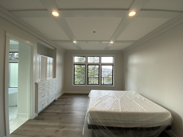 An empty bedroom with a bed and a window