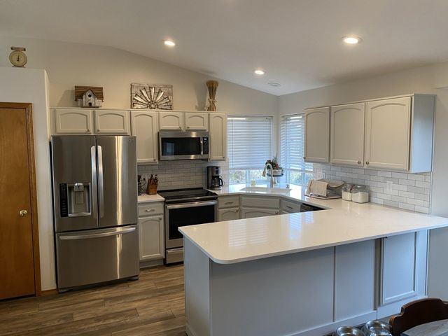A kitchen with stainless steel appliances and white cabinets