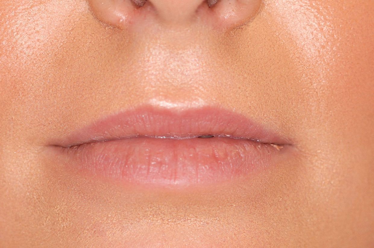 A close-up view of a person's mouth and nose area, showing the skin, lips, and cupid's bow.