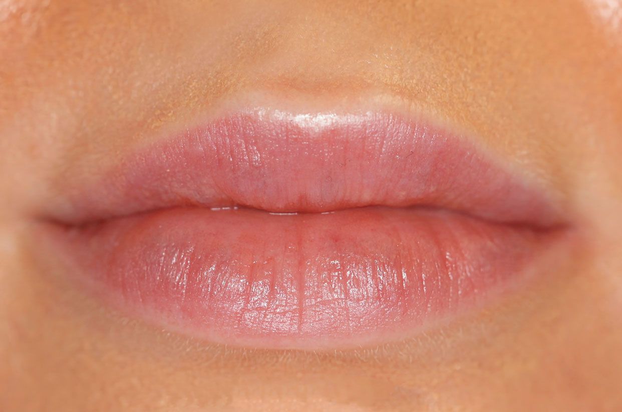 Close-up of full, pale pink lips.