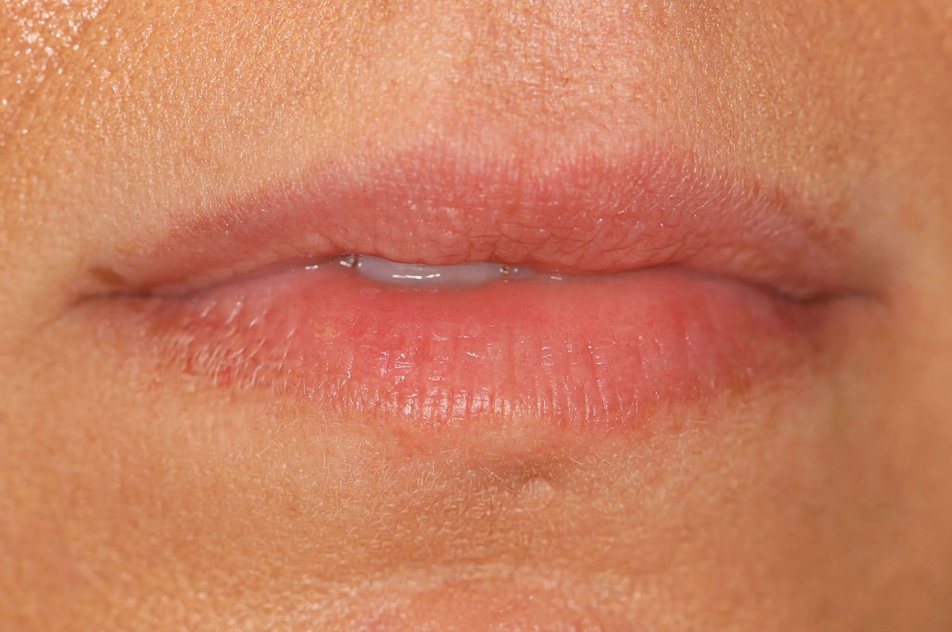 Close-up of human lips, pinkish in color, slightly parted.