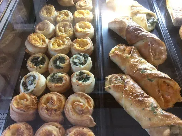 A variety of pastries are displayed in a glass case.